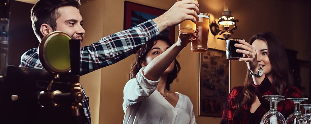 Happy multiracial friends making a toast with beer at bar or pub. Happy multiracial friends making a toast with beer at bar or pub.